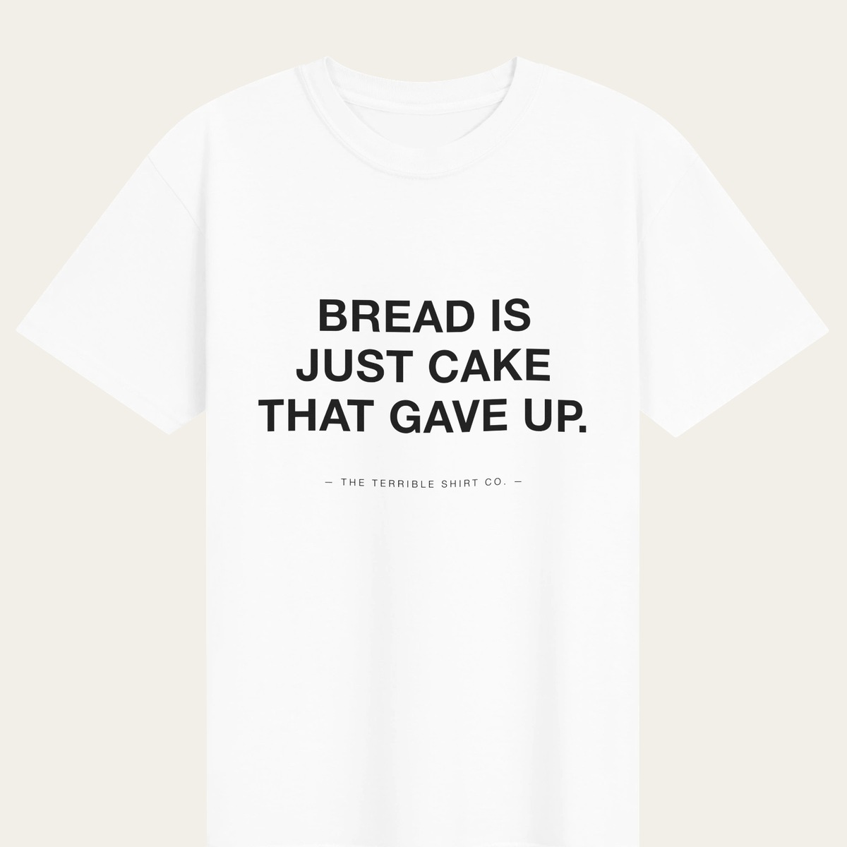A white heavyweight tee reading BREAD IS JUST CAKE THAT GAVE UP.